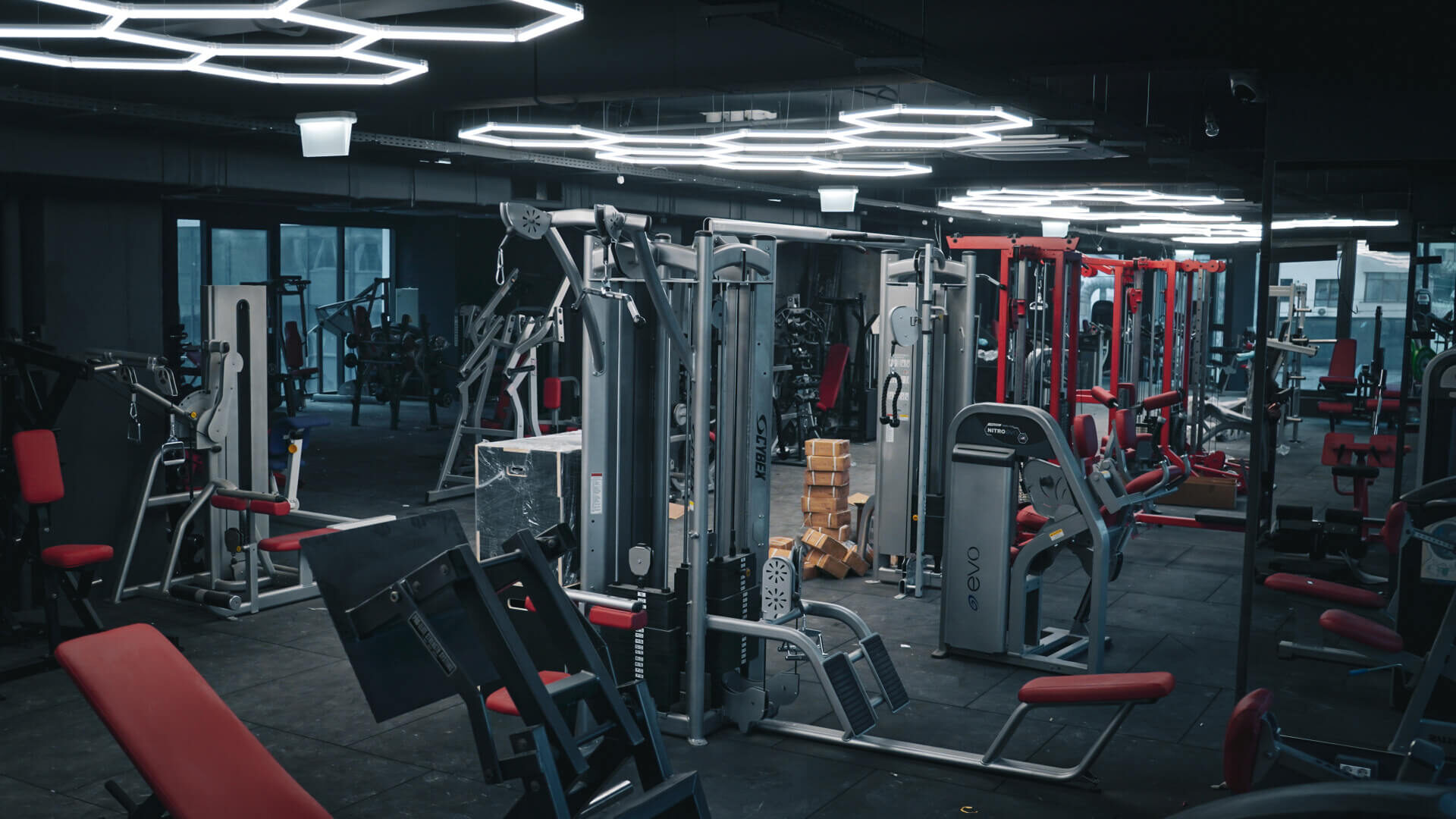 Sala Metalmorphose Gym Adamant, cu rasteluri de forță și grila de LED-uri hexagonale pe tavan.
